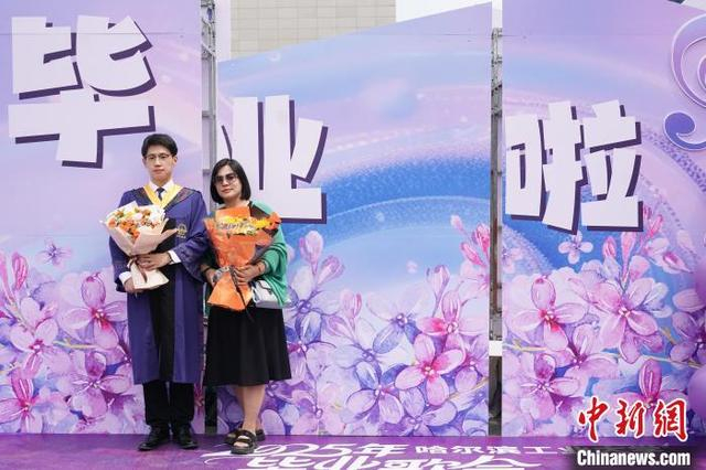 图为毕业生与家长合照。中新社记者 赵宇航 摄 