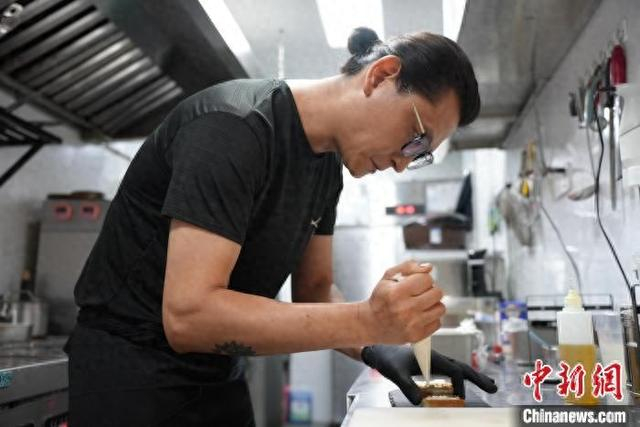 6月12日，江西南昌，李金阳在厨房忙碌。吴敏 摄