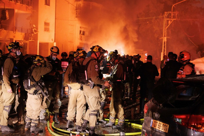 6月15日，在以色列北部城市海法，应急救援人员在导弹袭击现场工作。