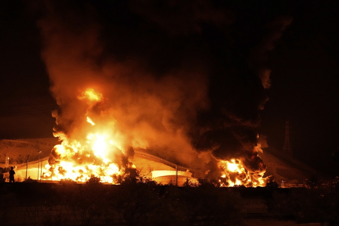 这是6月15日凌晨拍摄的伊朗首都德黑兰附近遭以色列袭击起火的储油设施。
