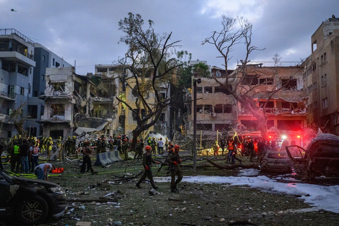 当地时间2025年6月16日，以色列特拉维夫市中心，救援人员和安全人员检查并清理被伊朗火箭弹击中的建筑物和区域。