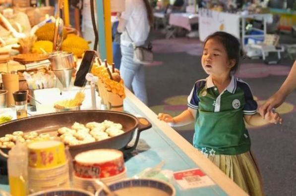 6月13日，在北京丰台花街夜市，摊位的食物吸引小朋友。中新社记者 张祥毅 摄