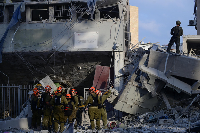 （6月16日，在以色列布内布拉克，应急和救援人员在一处导弹袭击现场开展工作。图片来源：新华社）