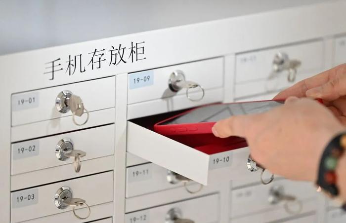 6月16日,在天津大学评卷点,工作人员将手机放入存放柜中。新华社记者 李然 摄