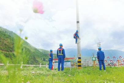 海来木加（右）在国网四川省电力公司喜德县供电分公司光明供电所辖区进行杆塔检修作业。 施少府 摄