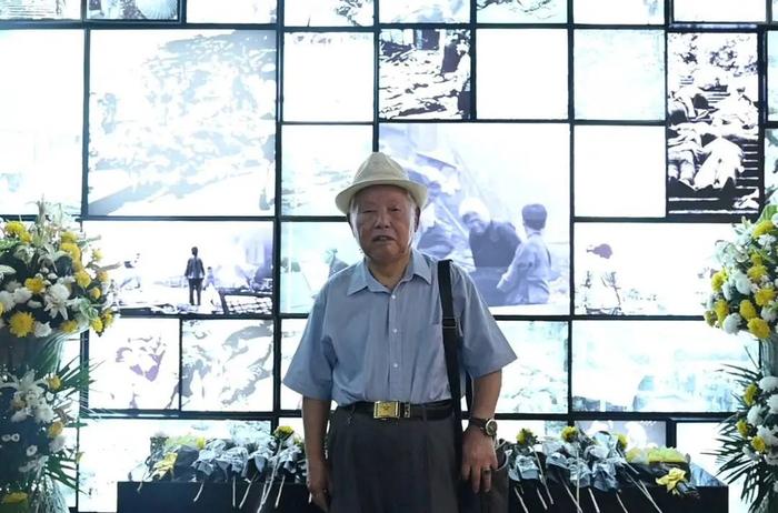 粟远奎老人站在重庆大轰炸历史影像前。