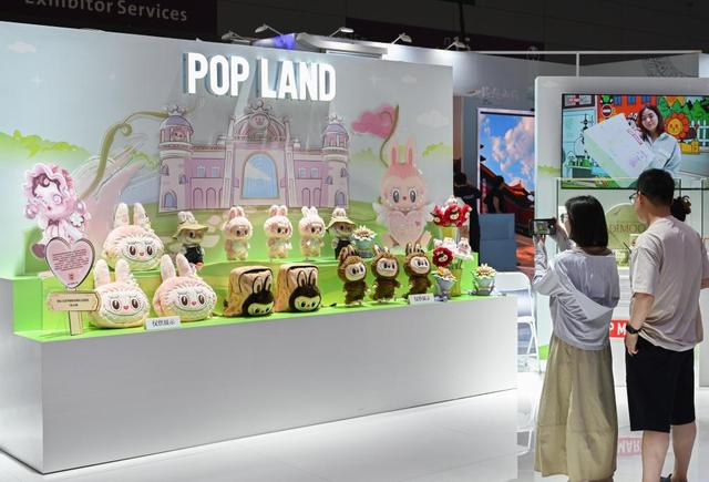 5月24日，在文博会北京展区，观众在泡泡玛特城市乐园展台前拍照。新华社记者 肖恩楠 摄