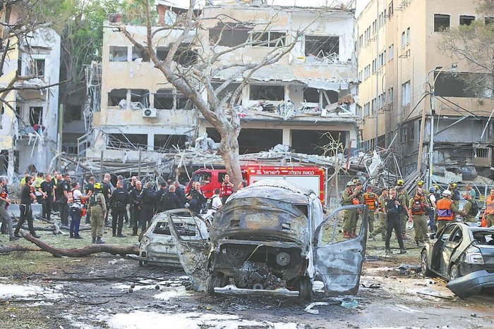     在以色列特拉维夫，应急和救援人员在一处导弹袭击现场开展工作。新华社发