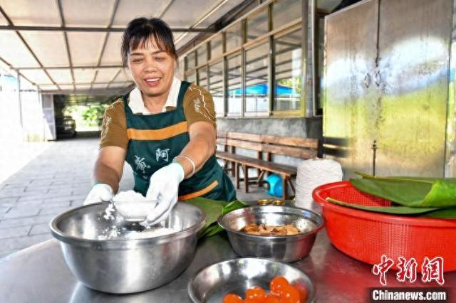 图为“黄阿姨”黄善梅为来访者演示定安粽的制作流程。中新网记者 骆云飞 摄