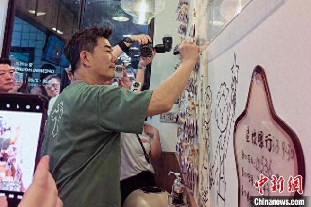 6月8日，任贤齐在位于福建省福州市的“星点心愿”茶咖饺子店内参观并签名。张秀丽 供图