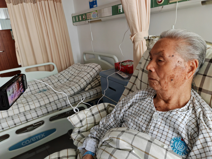 一审开庭时，郑蔚因为身体原因，躺在医院的病床上，通过视频连线的方式参加了庭审。受访者供图