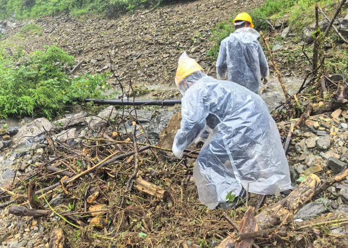 中国华电抢险人员清理被砂石掩埋的光纤