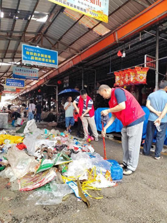 图为帮扶队伍帮助清扫垃圾现场照片。李群 摄