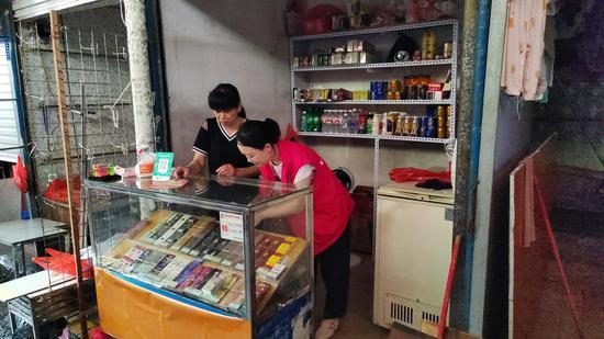 图为帮扶队员帮助受灾商户整理店面。王琪 摄