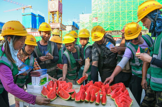 6月11日，在河北雄安新区启动区西北片区小学项目建设现场，中铁十二局工人吃西瓜解暑。新华社记者 牟宇 摄