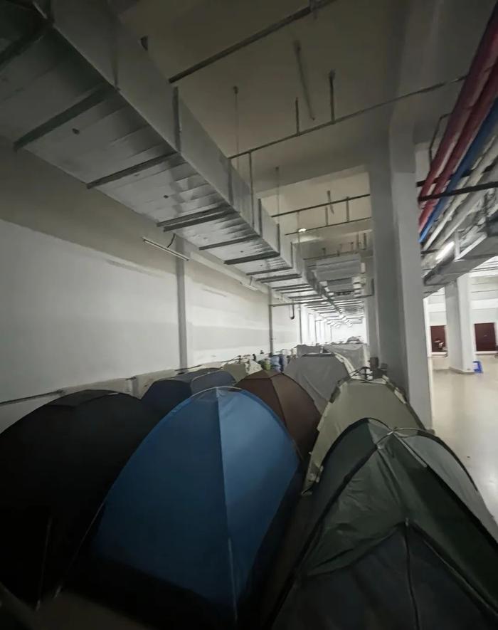 ▲学生们在吉林大学前卫南区宿舍楼地下室支帐篷过夜。受访者供图