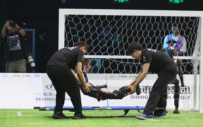 有机器人球员“受伤”，被担架抬下场“救治”。新京报记者 王子诚 摄