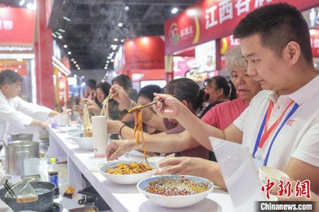 图为在2025米粉产业交易会现场，观众在一参展企业展台前试吃米粉。刘力鑫 摄