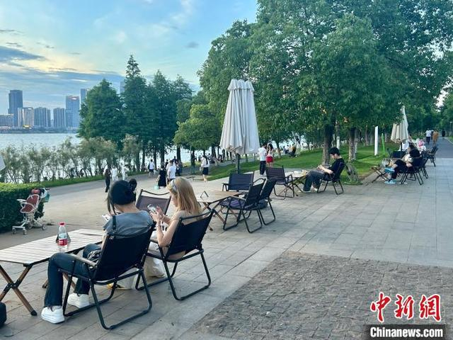 6月27日傍晚，江西省南昌市朝阳江滩公园，民众在江畔餐厅乐享夏日时光。 朱莹 摄