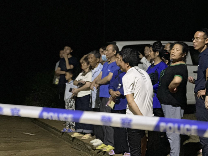 6月24日晚间，警戒线外的人群。