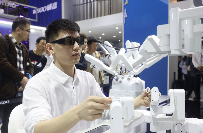 （在医疗器械展上展示的威高手术机器人。任玉明摄）