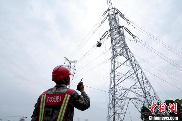 工作人员在220千伏线路工程施工现场指挥线路接线工作。冯一哲摄