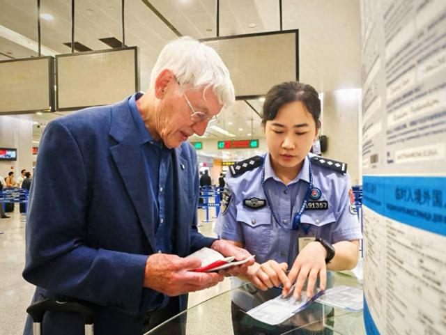 移民管理警察协助旅客完成通关。 韩志一 摄