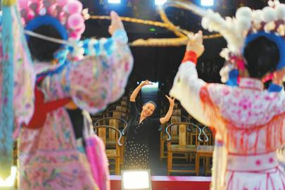 　　6月11日，川剧演员王秀芳（中）在三花川剧团为前来打卡拍照的年轻游客指导川剧造型。