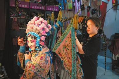 6月11日，年轻游客在三花川剧团里拍写真。