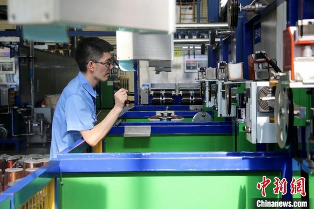 7月4日，在安徽铜陵精达漆包线有限公司漆包车间里，一位工作人员在查看机器运行状况。中新社记者 张强 摄