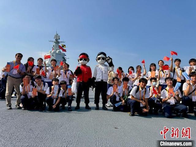 7月4日,山东舰举行开放参观活动。图为香港青少年和山东舰官兵装扮的“大熊猫”合影。中新社记者 戴梦岚 摄