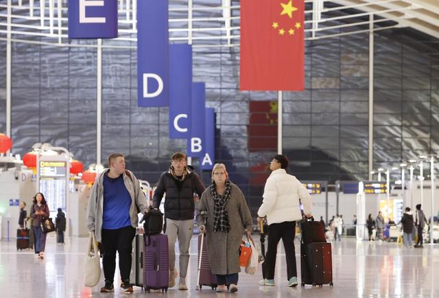 2024年12月31日晚，上海，外籍游客在浦东国际机场T2航站楼内行走。 视觉中国 图