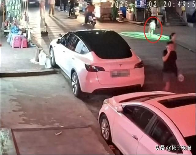 幼童独自一人站在路口门头广告投影灯产生的光影下玩耍 监控截图