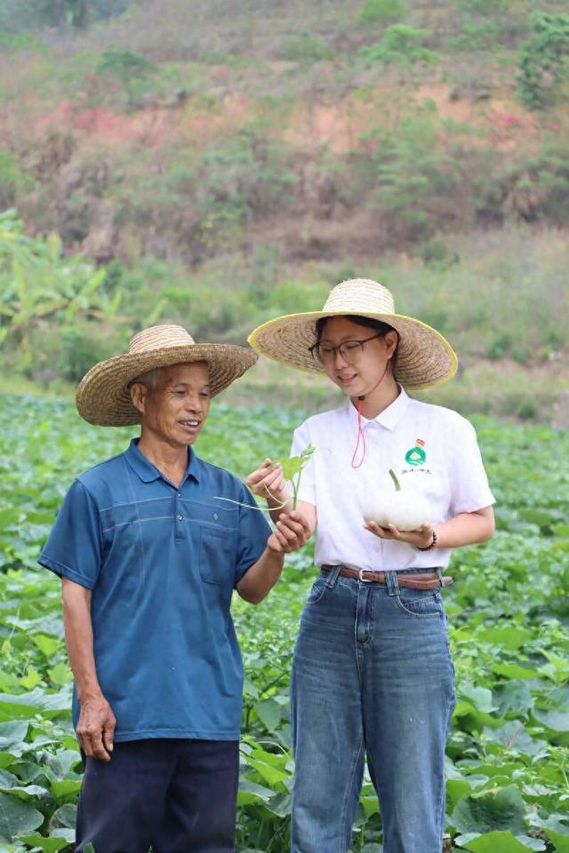 张祖瑜（右）与农户交流新品种性状。受访者供图