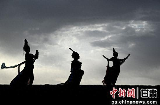 2025年6月7日清晨，身着“飞天”服饰的游客在甘肃省敦煌市鸣沙山月牙泉景区拍照。张晓亮 摄