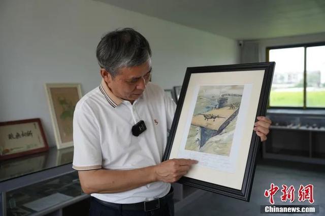 罗时平向记者展示杜立特行动油画。受访者供图
