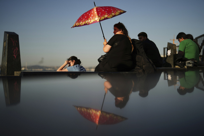 当地时间2025年7月8日，土耳其伊斯坦布尔，一名女子在炎热的夏日里遮阳。