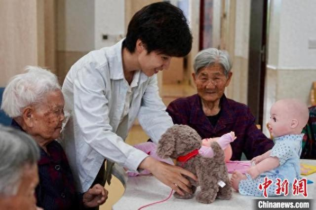 义乌市上溪镇养老服务中心院长陈智雅为老人介绍一些具有陪伴功能的适老化玩具。董易鑫 摄