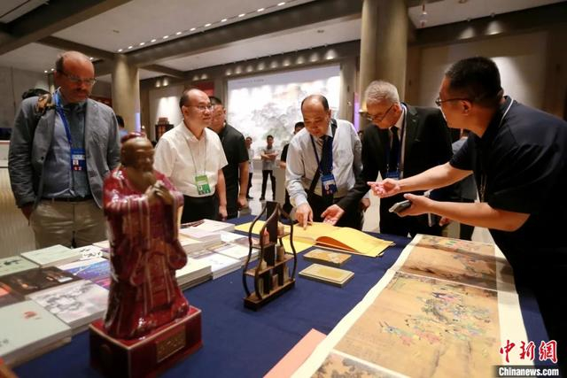 2025年7月9日，第十一届尼山世界文明论坛在山东曲阜启幕。图为中外嘉宾阅览儒家典籍、赏鉴文创产品。中新社记者 梁犇 摄