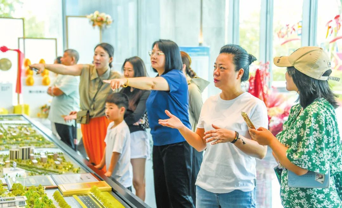 7月2日，在横沟村城市更新项目打造的中交·蓝色港湾未来社区展示区，村民正参观项目沙盘，憧憬美好新生活。康登淋 摄
