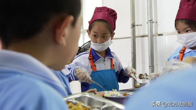  长春市南关区第一〇三中学校小学部教学楼走廊内，学生们正在参与分餐。新华社记者 张文嵘 摄