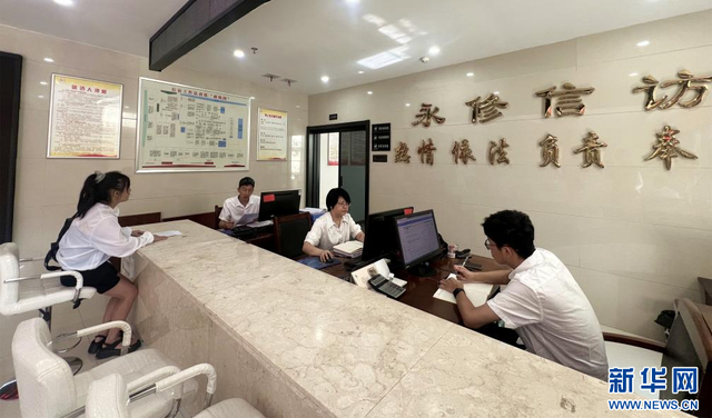 在江西省永修县信访接待窗口，工作人员为信访人员解答疑问。新华网 王晓震 摄