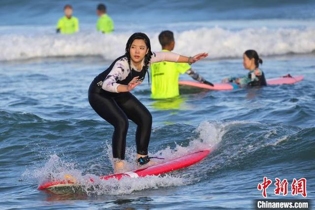 图为游客在日月湾体验冲浪运动。中新社记者 骆云飞 摄 