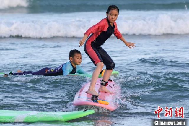 图为小朋友在日月湾体验冲浪运动。中新社记者 骆云飞 摄 