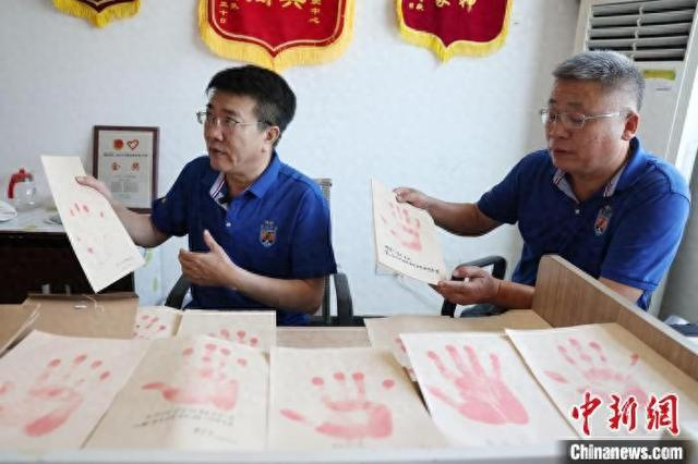 7月初，在长沙开福区的湖南老兵之家办公室，志愿者介绍老兵手印。中新网记者 杨华峰 摄