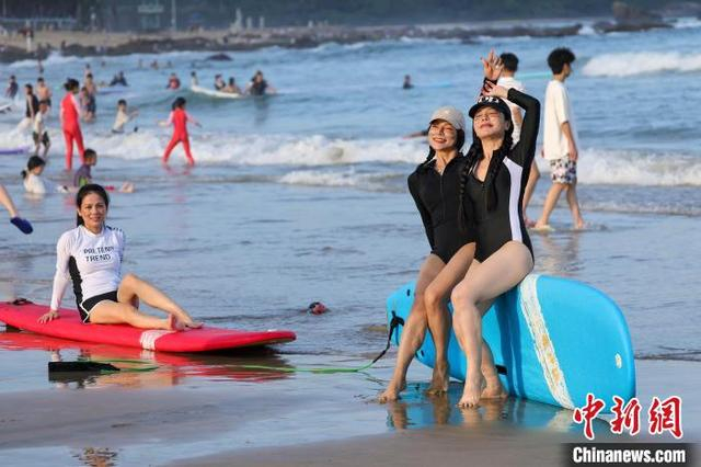 图为游客在日月湾体验冲浪后打卡拍照。中新社记者 骆云飞 摄 