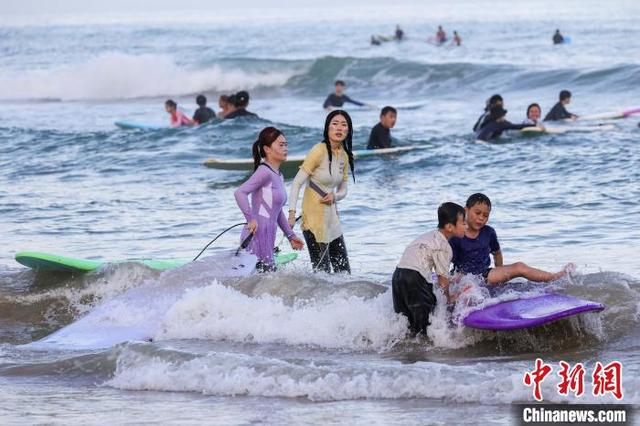 图为游客在日月湾体验冲浪运动。中新社记者 骆云飞 摄 