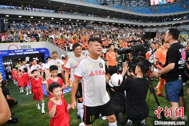 2023年6月28日晚，2023“迎大运”蓉港公益足球赛在成都举行。图为香港明星足球队队员走进赛场。 中新社记者 张浪 摄