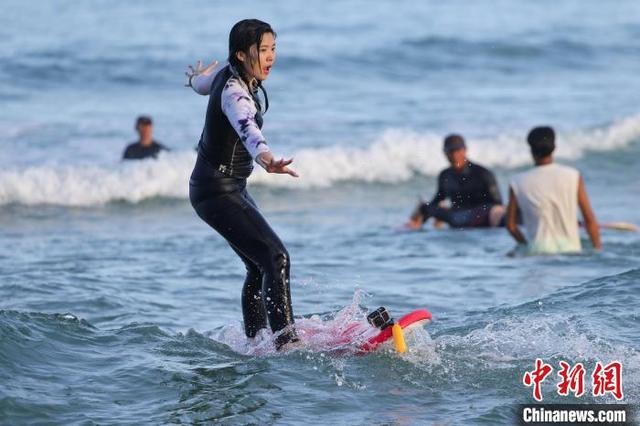 图为游客在日月湾体验冲浪运动。中新社记者 骆云飞 摄 