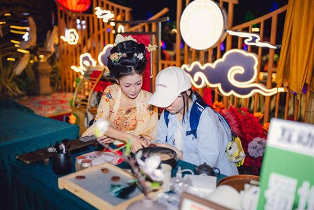 夜游锦江的游客与“薛涛”NPC互动制作香囊。新华社发（唐斌治 摄）